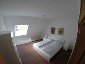 ein weißes Schlafzimmer mit einem Bett und einem Fenster in der Unterkunft Apartment in Winterberg 2812 in Winterberg