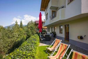 eine Gruppe von Stühlen auf einem Rasen neben einem Gebäude in der Unterkunft Apartment Zell am Ziller/Zillertal 841 in Zell am Ziller