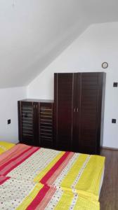 a bedroom with a bed and some wooden cabinets at Apartment Balatonlelle 6 in Balatonlelle