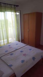 a bedroom with a bed and a wooden cabinet at Apartment Lopar, Primorje-Gorski Kotar 4 in Lopar