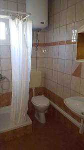a bathroom with a toilet and a tub and a sink at Apartment Lopar, Primorje-Gorski Kotar 4 in Lopar