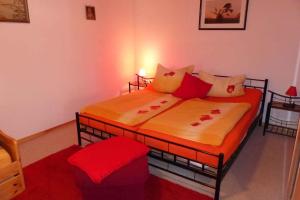 1 Schlafzimmer mit 2 Betten mit roten und orangefarbenen Kissen in der Unterkunft Apartment Fuhlendorf 2 in Bodstedt