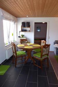 ein Esszimmer mit einem Holztisch und Stühlen in der Unterkunft Apartment Fuhlendorf 2 in Bodstedt