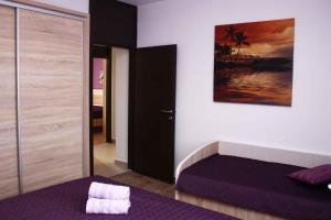 a bedroom with a bed and a painting on the wall at Apartment in Grebastica 7034 in Grebaštica