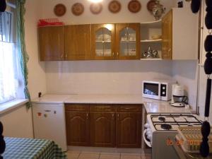バラトンボグラールにあるApartment in Balatonboglar - Balaton 18183の木製のキャビネットとコンロ付きオーブンを備えたキッチン +12枚の写真
