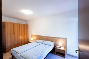 Apartment Tremosine 7 في تريموسين سول جاردا: غرفة نوم بسرير كبير وموقف ليلتين