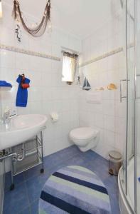 ein weißes Bad mit einem Waschbecken und einem WC in der Unterkunft Apartment Bergen auf Rügen 5 in Mölln-Medow