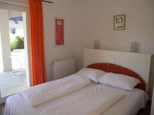 a bed in a bedroom with an orange curtain at Holiday home in Siofok - Balaton 20063 in Siófok +17 photos
