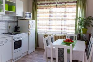 a kitchen with a table with a bowl of fruit on it at Apartment Gyenesdias 15 in Gyenesdiás