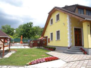 バラトンフューズフーにあるHoliday home Balatonfűzfo/Balaton 18801の花の庭と中庭のある黄色い家