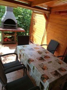 a table and chairs on a patio with a stove at Holiday home in Gyenesdias - Balaton 18865 in Gyenesdiás