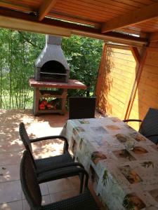 a table and chairs on a patio with a stove at Holiday home in Gyenesdias - Balaton 18865 in Gyenesdiás