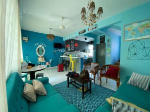 Suhana HomeStay Semporna - Cozy Home في سيمبورنا: غرفة معيشة مع جدران زرقاء وأريكة زرقاء
