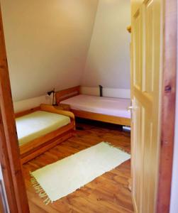 EbhegyにあるHoliday home in Balatonszarszo 20093のベッド2台とドアが備わる小さな部屋です。