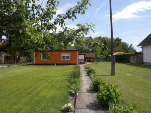 a house in a yard with a green lawn at Holiday home in Balatonfenyves 18379 in Balatonfenyves