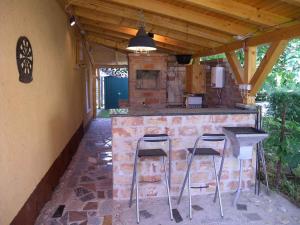 una cocina al aire libre con 2 taburetes y una barra en Holiday home in Fonyod/Balaton 18622, en Balatonfenyves