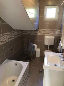 a bathroom with a tub and a toilet and a sink at Apartment Kampor 3 in Kampor