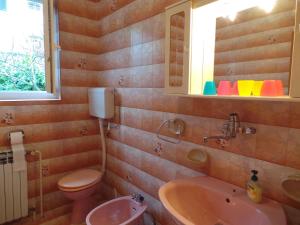 een badkamer met een wastafel, een toilet en een spiegel bij Apartment Lovran 15546 in Opric