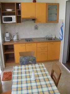 a small kitchen with a table and a sink at Apartment Lopar 1 in Lopar