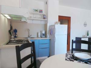 a kitchen with a white refrigerator and a table with chairs at Apartment in Medulin/Istrien 9043 in Medulin