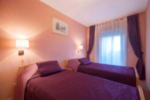 a hotel room with two beds and a window at Apartment Pula, Istria Country 1 in Vintijan