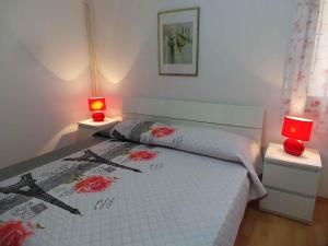 a bedroom with a bed with two red lamps at Apartment Medulin, Istria 2 in Medulin