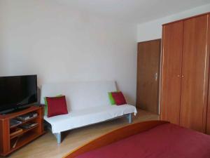 a living room with a white couch and a television at Apartment Fazana, Istria 11 in Fažana