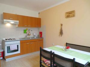 a kitchen with a table and a sink and a stove at Apartment Fazana, Istria 11 in Fažana