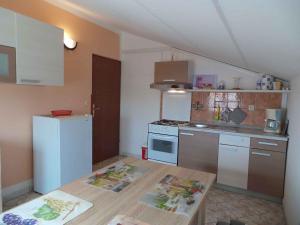 a small kitchen with a white refrigerator and a table at Apartment Fazana 15 in Fažana