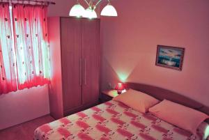 Schlafzimmer mit einem Bett mit rosa Wänden in der Unterkunft Holiday home in Muntic/Istrien 10956 in Muntić