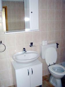 ein Badezimmer mit einem weißen Waschbecken und einem WC in der Unterkunft Apartment Medulin 12 in Medulin