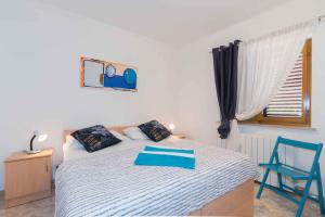 1 dormitorio con 1 cama y 1 silla azul en Apartment in Plomin/Istrien 8771 en Plomin