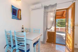 a dining room with a white table and blue chairs at Apartment in Plomin/Istrien 8771 in Plomin