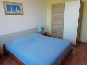 a bedroom with a bed with a blue bedspread at Apartment Valbandon 13 in Štinjan