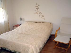 a bed and a chair in a small room at Apartment Medulin 10 in Medulin