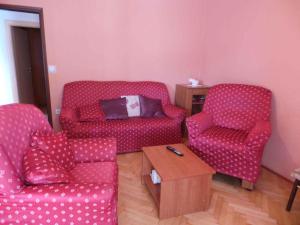a living room with two red chairs and a coffee table at Apartments in Valbandon/Istrien 8381 in Štinjan