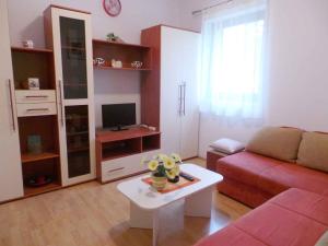 ein Wohnzimmer mit einem roten Sofa und einem Tisch in der Unterkunft Apartment in Mali Vareski/Istrien 8693 in Mali Vareški