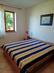 a large bed in a room with a window at Apartment Valbandon 3 in Štinjan
