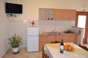 a kitchen with a table and a white refrigerator at Apartment Valbandon 3 in Štinjan