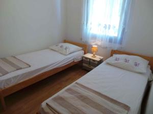 2 łóżka w małym pokoju z oknem w obiekcie Holiday home in Medulin/Istrien 8949 w Medulinie
