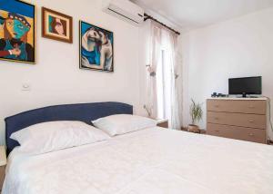 a bedroom with a white bed and a television at Apartment in Banjole/Istrien 11157 in Banjole