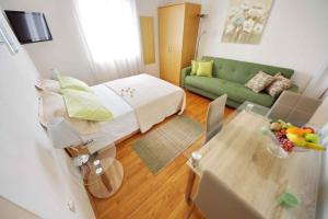 a living room with a bed and a green couch at Apartment Vrsi -Mulo 2 in Kod Mula