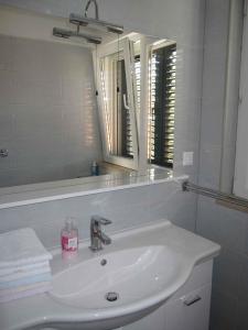 ein weißes Badezimmer mit einem Waschbecken und einem Spiegel in der Unterkunft Apartment in Supetar/Insel Brac 5905 in Supetar