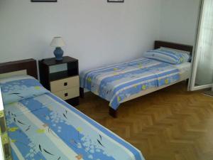 ein Schlafzimmer mit 2 Betten und einem Nachttisch mit einer Lampe in der Unterkunft Apartment in Supetar/Insel Brac 5905 in Supetar