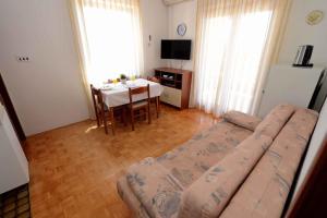 ein Wohnzimmer mit einem Sofa und einem Tisch in der Unterkunft Apartment Zadar 17 in Diklo