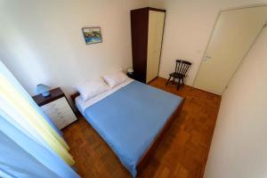 a small bedroom with a bed and a chair at Apartment Kozino 12 in Kožino
