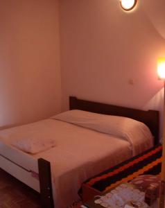 a small bedroom with a bed with white sheets at Apartment Zlarin 1 in Zlarin