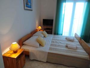 a bedroom with a large bed with two pillows at Apartments in Sabunike/Zadar Riviera 7981 in Batalaži