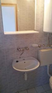 a white sink in a bathroom with a window at Apartment Zaglav 2 in Zaglav