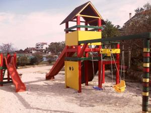 une aire de jeux avec un toboggan rouge et jaune dans l'établissement Holiday home Zaglav/Insel Dugi Otok 6296, à Zaglav